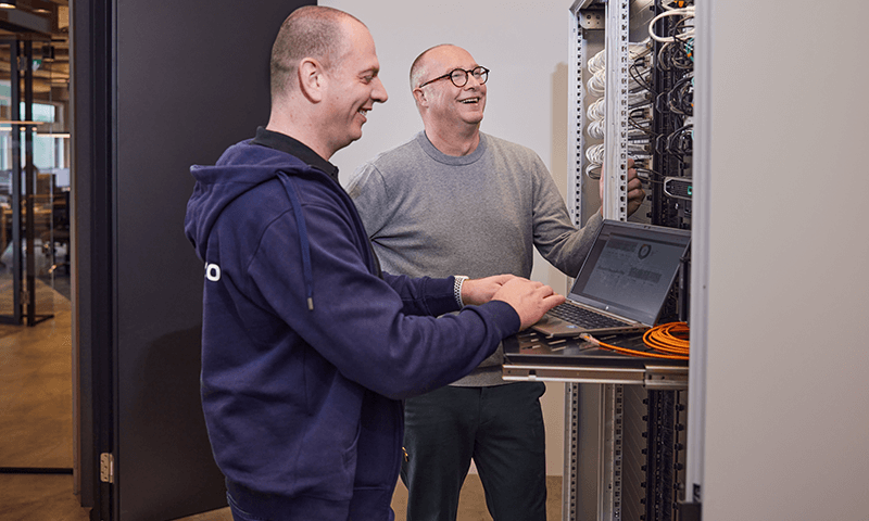 Wentzo collega staat met zijn laptop bij de patchkast van Ster samen met systeembeheerder Marc Punte