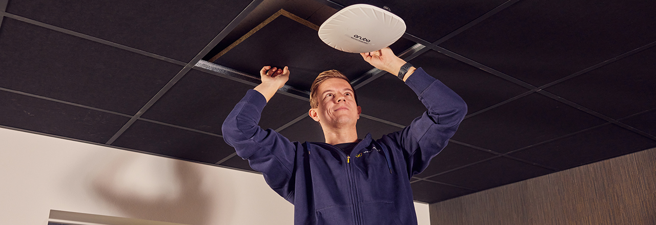 Een Wentzo collega hangt een access point van Aruba op.