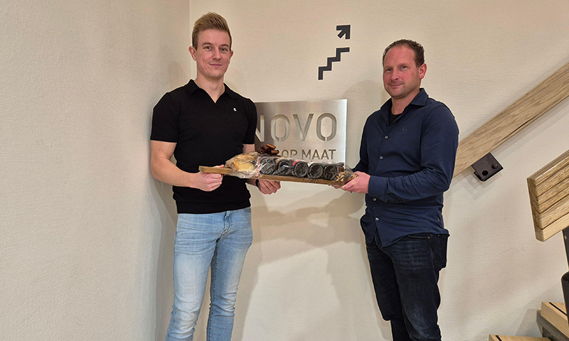 Wentzo collega overhandigt een borrelplank aan INNOVO voor de oplevering van het nieuwe netwerk.