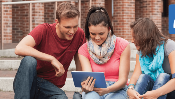 Drie studenten zitten op de trap en kijken naar een tablet die gebruik maakt van WiFi