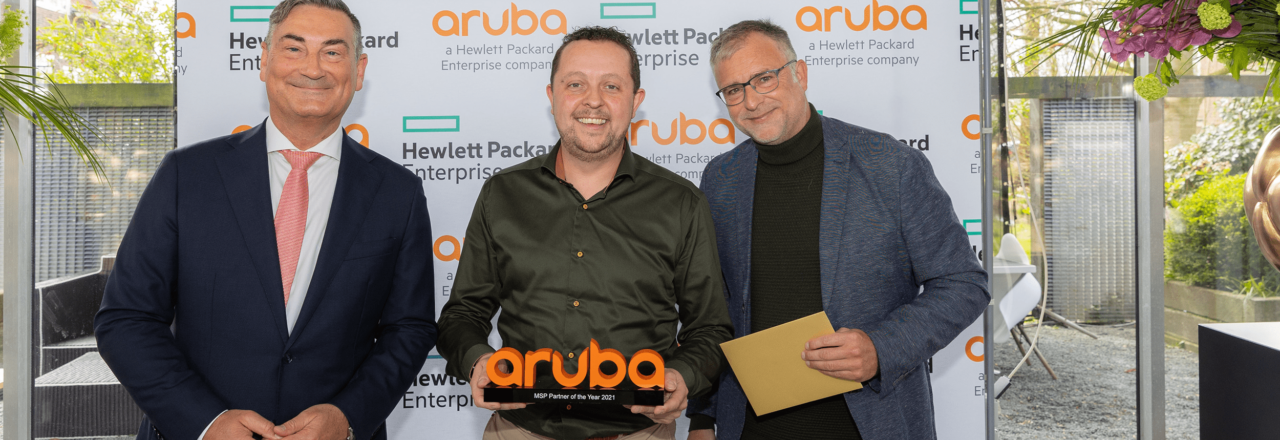 Martijn Wentzel houdt de Aruba MSP Partner Of The Year 2021 award vast. Er staan twee Aruba collega's naast hem.