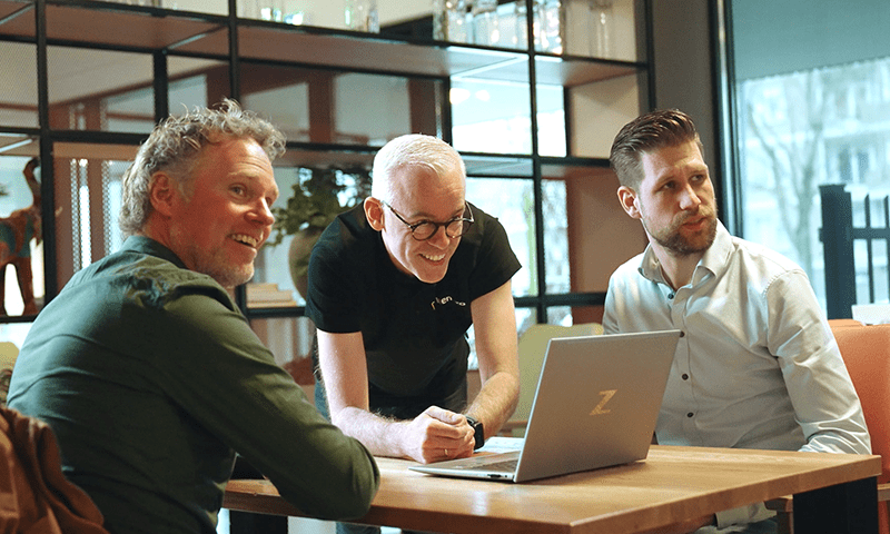 Manager Bedrijfsvoering Archipel Zorggroep en Wentzo collega's kijken blij naar een laptop.