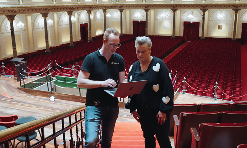 Een Wentzo collega staat met iemand van Het Concertgebouw in de Grote Zaal en laat de resultaten van de Site Survey op zijn laptop zien