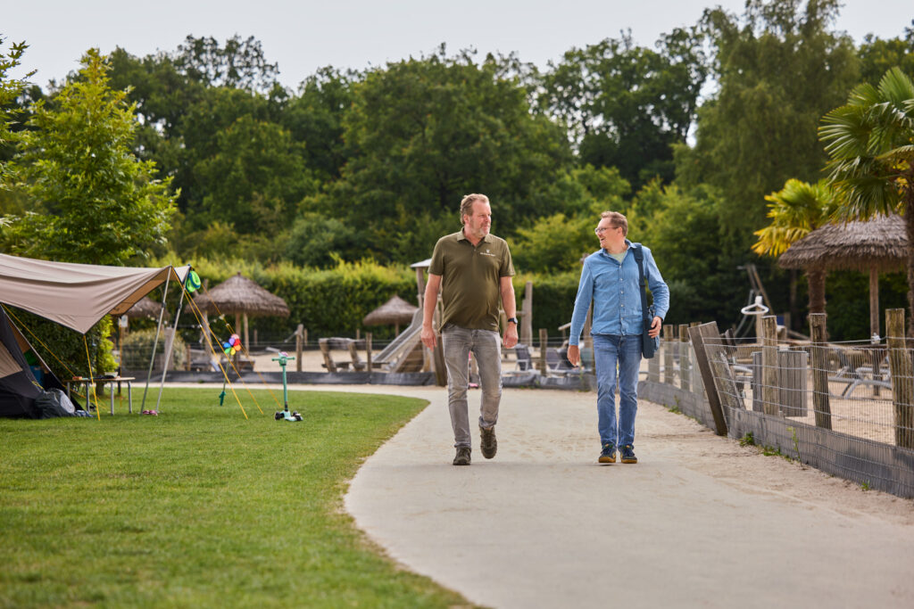 Een Wentzo collega loopt samen met de technisch manager over camping De Kleine Wolf